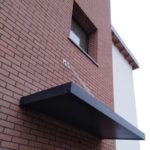 Tettoia sospesa con struttura in tubolare e lamiera tagliata al laser zincata e verniciata retta da due tiranti in acciaio