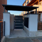 Tettoia sospesa con struttura in tubolare e lamiera tagliato al laser sorretta da quattro piantoni a copertura di uno degli ingressi con cancelletto pedonale in lamiera tagliata al laser e maniglione in acciaio inox e realizzazione della copertura per i contatori il tutto zincato e verniciato