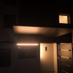 Tettoia sospesa con struttura in tubolare e lamiera tagliato al laser retta da un tirante in acciaio e tre piantoni a copertura di uno degli ingressi con cancelletto pedonale in lamiera tagliata al laser e maniglione in acciaio inox il tutto zincato e verniciato con illuminazione a led di sera